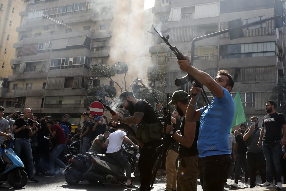 Supporters of the Shiite Amal group fire weapons in the air during the funeral processions of Hassan Jamil Nehmeh, who was killed during yesterday clashes, in the southern Beirut suburb of Dahiyeh, Lebanon, Friday, Oct. 15, 2021. Dozens of gunmen opened fire in the air Friday south of Beirut during the funeral of persons killed in hours of gun battles between heavily armed gunmen the day before that left several people dead and terrorized the residents of Beirut. (AP Photo/Bilal Hussein)