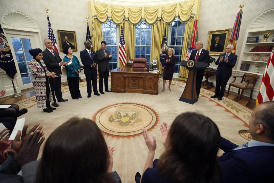 President Donald Trump speaks as Homeland Security Secretary Kirstjen Nielsen, Vice President Mike Pence, right, listen during a naturalization ceremony for five people, at left, in the Oval Office of the White House, in Washington, Saturday, Jan. 19, 2019. (AP Photo/Alex Brandon)