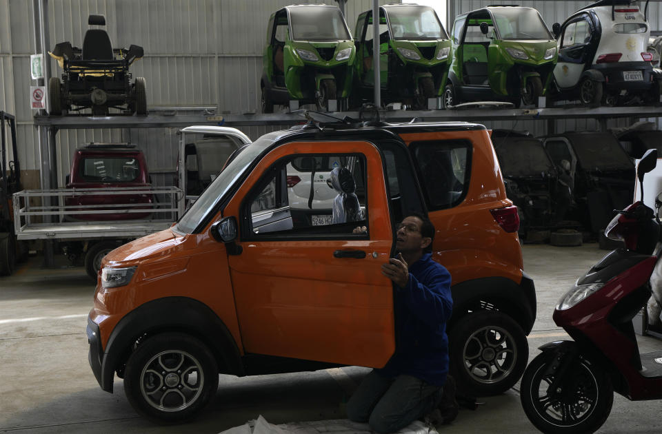 An employee works on a Quantum electric car at a factory in Cochabamba, Bolivia, Tuesday, May 9, 2023. Quantum, a tiny EV that fits three, is the creation of a group of Bolivian entrepreneurs who believe electric vehicles are the future of the automotive industry in this lithium-rich country. (AP Photo/Juan Karita)