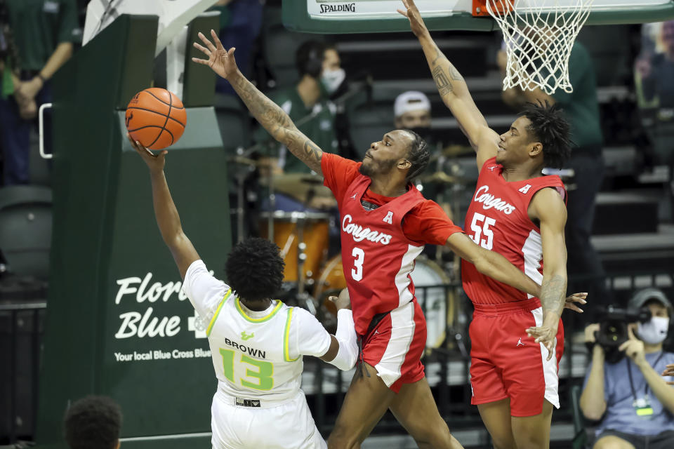 South Florida's Justin Brown (13) has his shot defended by Houston's DeJon Jarreau (3) and Brison Gresham during the first half of an NCAA college basketball game Wednesday, Feb. 10, 2021, in Tampa, Fla. (AP Photo/Mike Carlson)
