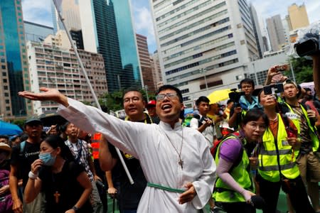 A priest urges people to join a protest in Hong Kong