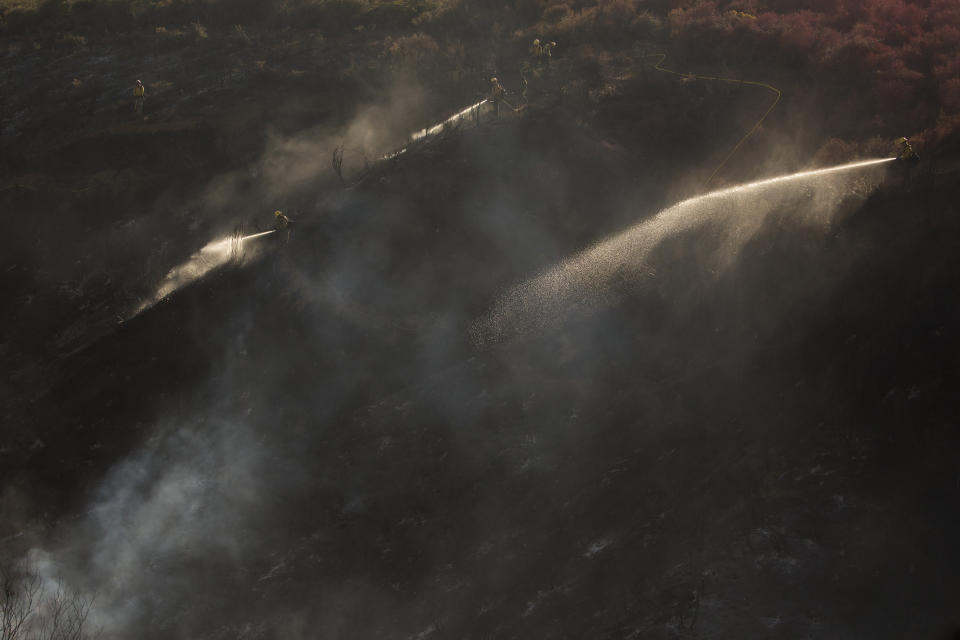 Hand crews work on the remaining hot spots from a brush fire at the Apple Fire in Cherry Valley, Calif., Saturday, Aug. 1, 2020. (AP Photo/Ringo H.W. Chiu)