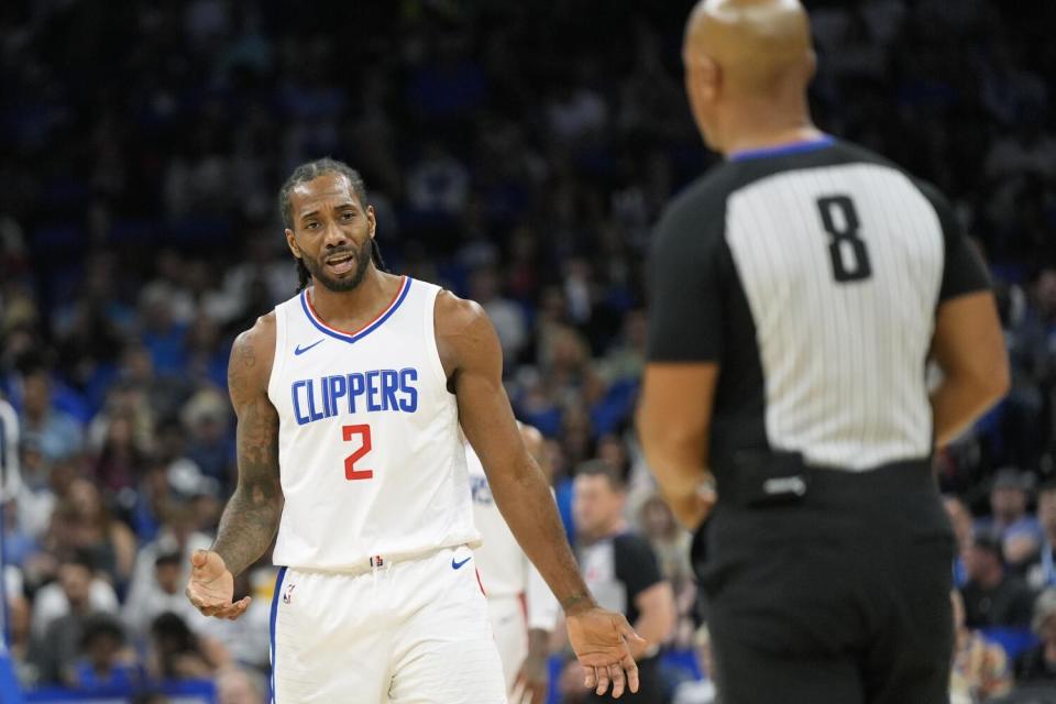 Clippers forward Kawhi Leonard, left, questions a call by official Marc Davis during a game earlier this season.