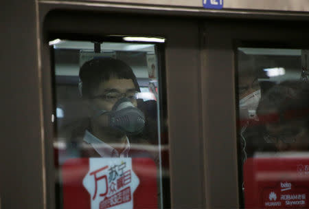 A man wearing a respiratory protection mask is pictured in the subway after a red alert was issued for heavy air pollution in Beijing, China, December 20, 2016. REUTERS/Jason Lee