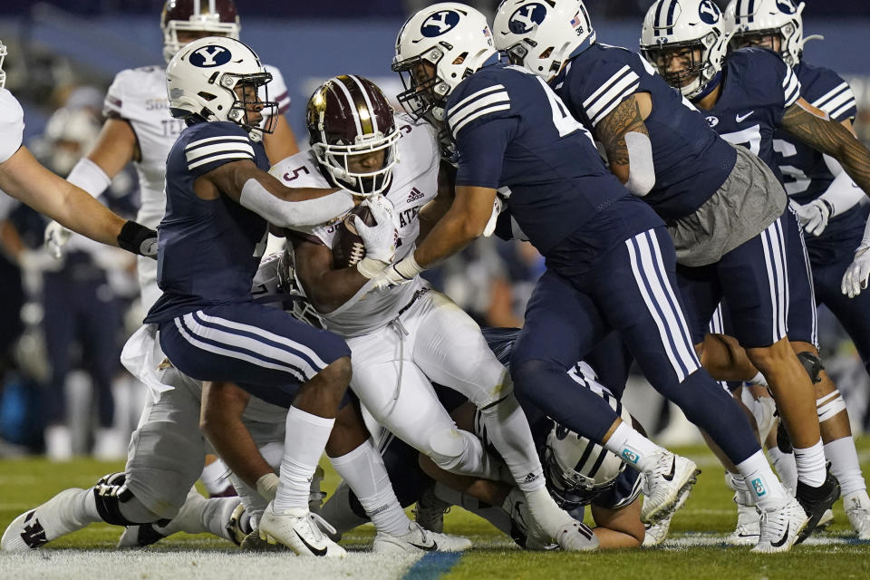 BYU's George Udo, left, and Pepe Tanuvasa, right, tackle Texas State running back Brock Sturges (5) in the first half during an NCAA college football game Saturday, Oct. 24, 2020, in Provo, Utah. (AP Photo/Rick Bowmer)