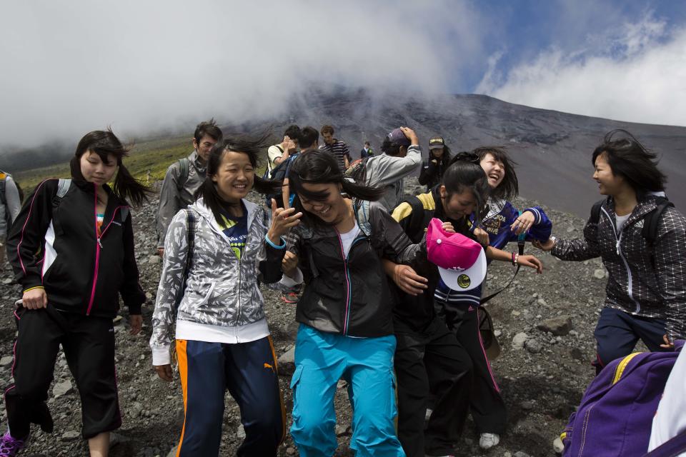 In this Thursday, Aug. 29, 2013 photo, Japanese students make their way down a steep trail on Mount Fuji in Japan during a school putting to learn about the mountain environment and pick up any trash they could find on the trails. The Japanese cheered the recent recognition of Mount Fuji as a UNESCO World heritage site, though many worry that the status may worsen the damage to the environment from the tens of thousands who visit the peak each year. (AP Photo/David Guttenfelder)