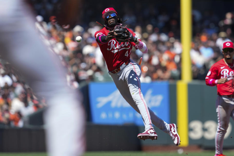 Cincinnati Reds shortstop Elly De La Cruz, center, throws to first base on a single hit by San Francisco Giants' Blake Sabol during the fifth inning of a baseball game Sunday, May 12, 2024, in San Francisco. Giants' Heliot Ramos scored and Sabol reached third on a throwing error by De La Cruz. (AP Photo/Godofredo A. Vásquez)