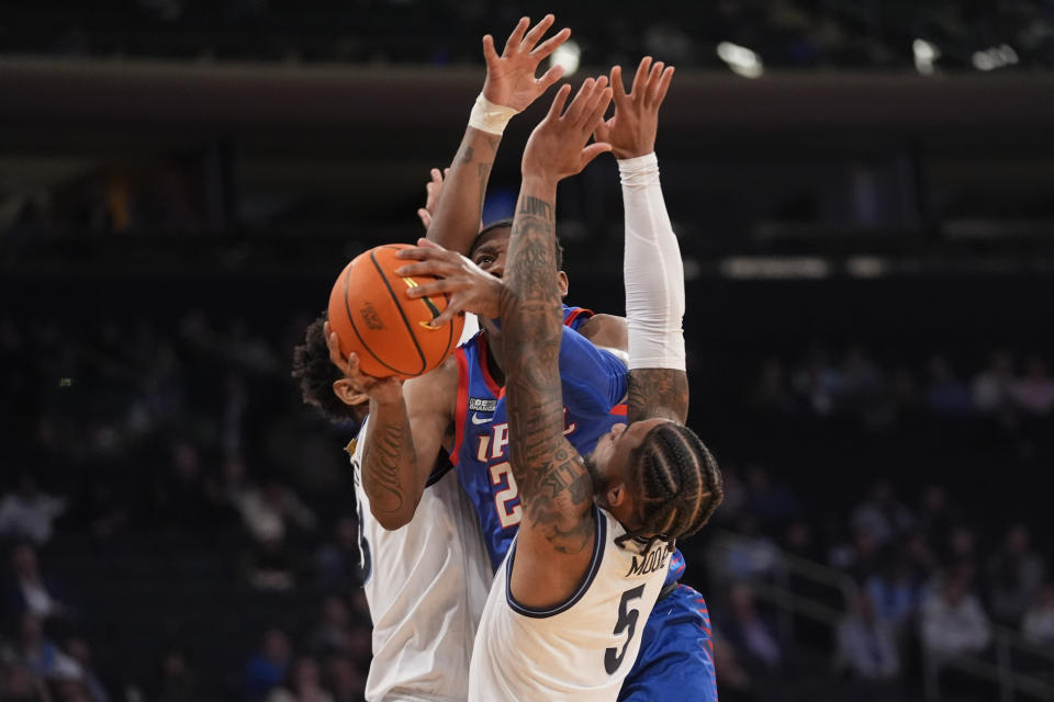 DePaul guard Elijah Fisher goes to the basket against Villanova guard Justin Moore and forward Tyler Burton during the second half of an NCAA college basketball game in the first round of the Big East Conference tournament, Wednesday, March 13, 2024, in New York. (AP Photo/Mary Altaffer)