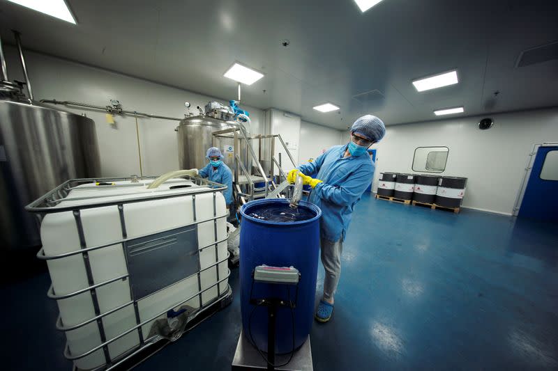 Employees mix chemicals into a steamer tank to make hand-sanitizers at Dhaman Medical Company, following the outbreak of the coronavirus disease (COVID-19), in Hidd