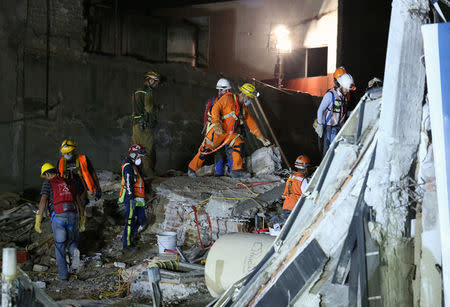 Members of rescue teams search for survivors, in the rubble of a collapsed building, after an earthquake in Mexico City, Mexico September 25, 2017. REUTERS/Henry Romero