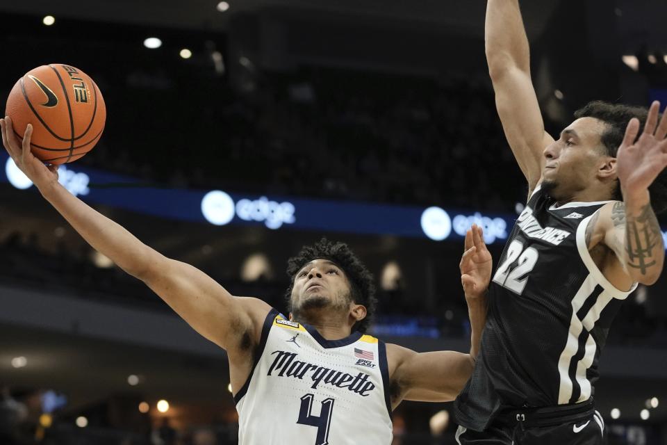 Marquette's Stevie Mitchell is fouled by Providence's Devin Carter during the first half of an NCAA college basketball game Wednesday, Jan. 18, 2023, in Milwaukee. (AP Photo/Morry Gash)