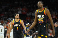 Phoenix Suns guard Devin Booker (1) and forward Kevin Durant (35) walk to their bench during the second half of Game 6 of an NBA basketball Western Conference semifinal series against the Denver Nuggets, Thursday, May 11, 2023, in Phoenix. The Nuggets eliminated the Sun in their 125-100 win. (AP Photo/Matt York)