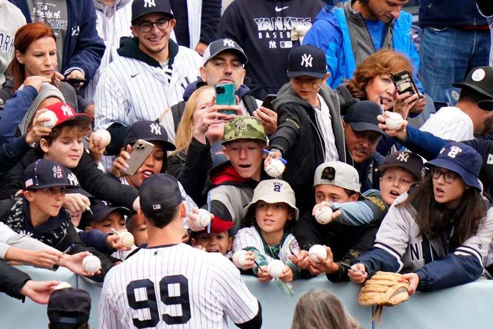 New York Yankees' Aaron Judge (99) signs autographs before a baseball game against the Baltimore Orioles Sunday, Oct. 2, 2022, in New York. (AP Photo/Frank Franklin II)