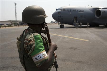 An African Union (AU) peacekeeper for the Central African Republic (MISCA) keeps guard as a U.S. Air Force plane lands carrying the first contingent of Rwandan AU soldiers at the capital Bangui January 16, 2014. REUTERS/Siegfried Modola