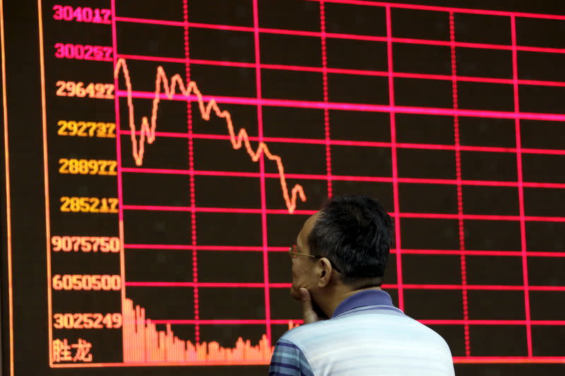 FILE PHOTO: An investor looks at an electronic board showing stock information of Shanghai Stock Exchange Composite Index at a brokerage house in Beijing, August 26, 2015. REUTERS/Jason Lee