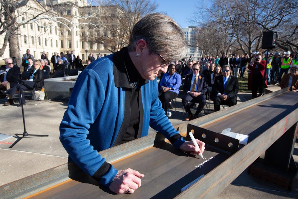 Gov. Laura Kelly signs her name on a metal beam that will become part of the new Docking State Office Building during a ceremony Monday.