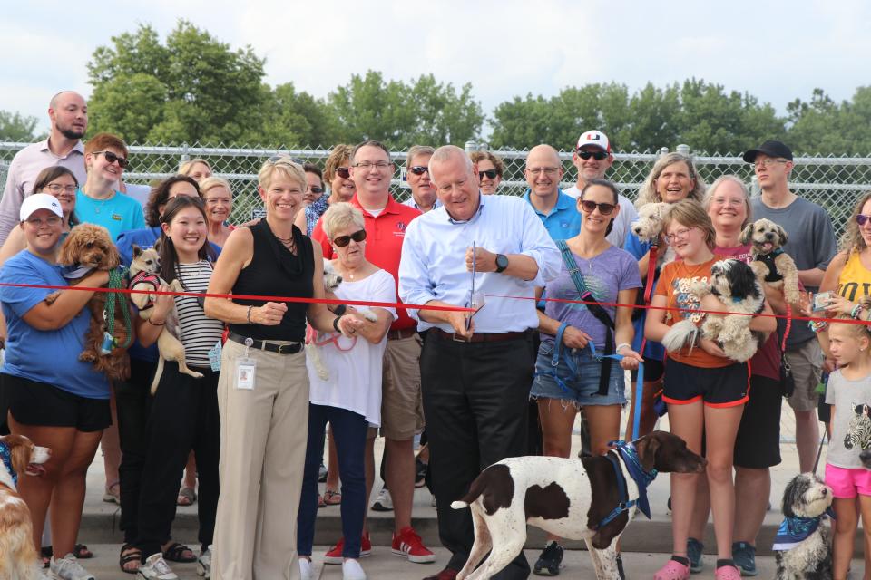 Urbandale Mayor Bob Andeweg cuts a ribbon to open the city's first public dog park on Thursday, Aug. 3, 2023. The park is located at 4905 68th St.