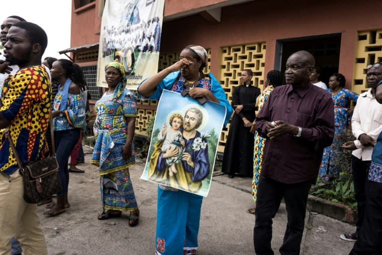 A Catholic wipes her eyes after police fired tear gas to disperse a demonstration calling for Democratic Republic of Congo President Joseph Kabila to step down, on December 31, 2017 in Kinshasa