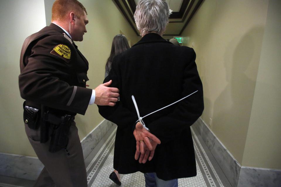 A LGBT rights activist is arrested by the Utah Highway Patrol after blocking a Senate committee hearing room at the Utah State Capitol in Salt Lake City February 10, 2014. LGBT rights activists are demanding the Legislature consider an anti-discrimination bill, Senate Bill 100, which the Senate has declined to do so. (REUTERS/Jim Urquhart)