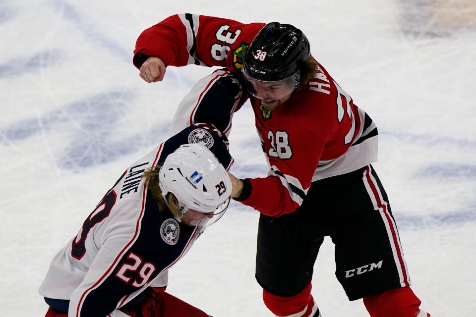 Columbus Blue Jackets' Patrik Laine, left, and Chicago Blackhawks' Brandon Hagel fight during the first period of an NHL hockey game in Chicago, Saturday, Feb. 13, 2021. (AP Photo/Nam Y. Huh)