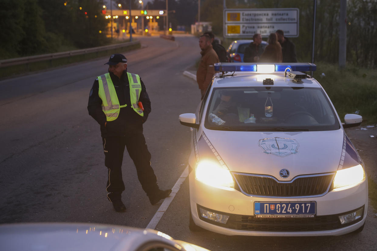 Police officers block the road near the village of Mali Pozarevac, some 50 kilometers (30 miles) south of Belgrade, Serbia, Friday, May 5, 2023. A shooter killed at least eight people and wounded 13 in a drive-by attack near a town close to Belgrade late Thursday, the second such mass killing in Serbia in two days, state television reported. (AP Photo/Armin Durgut)
