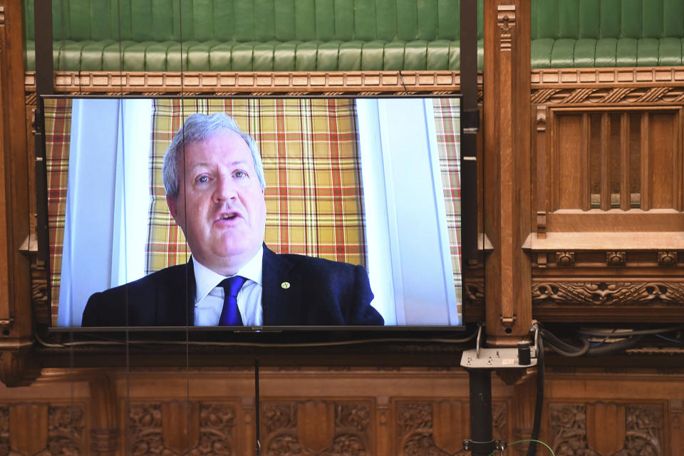 In this handout photo provided by UK Parliament, SNP Westminster leader Ian Blackford asks a a question remotely during Prime Minister's Questions, as members of parliament observe social distancing due to the coronavirus, in the House of Commons, London, Wednesday, May 6, 2020. (Jessica Taylor/UK Parliament via AP)