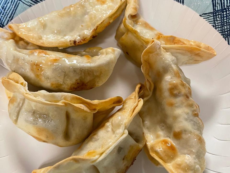 cooked trader joe's chicken gyoza on a paper plate