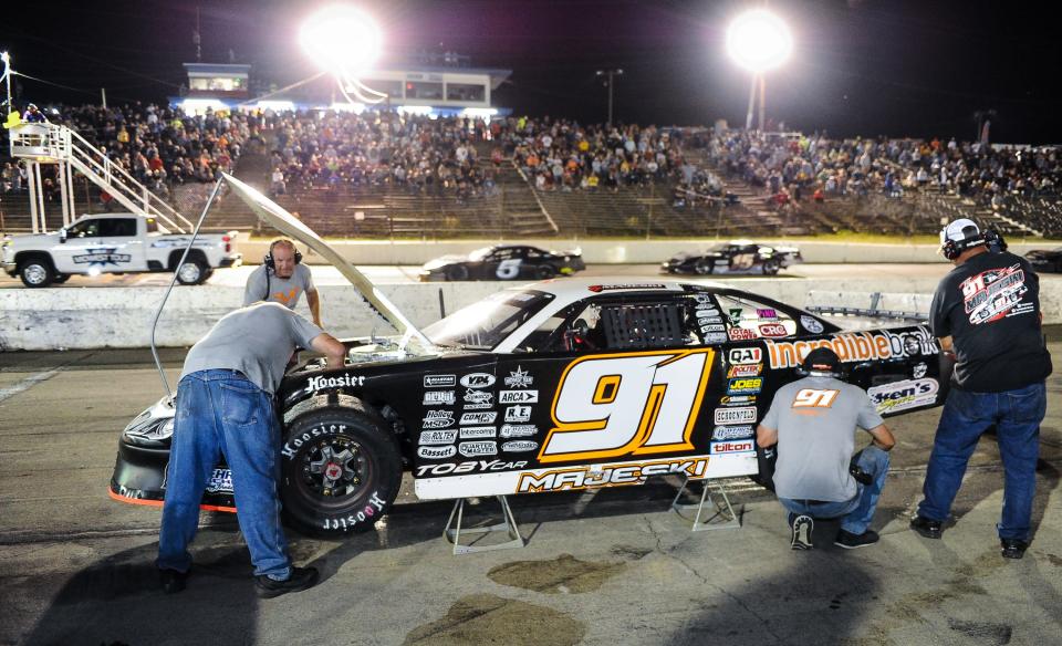 Ty Majeski's crew adds power steering fluid to his car on a late pit stop Tuesday night.