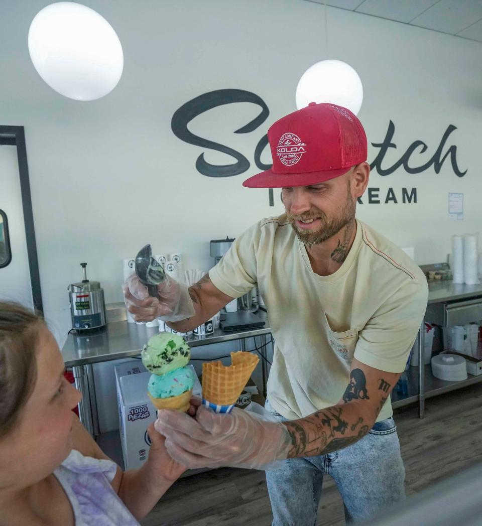 Ryan Povlick and his daughter Gianna work together to put double scoops on an ice cream cone on May 23, 2023 at Scratch Ice Cream in Brookfield. "My favorite part is having a business that my daughter enjoys coming to," Povlick said.