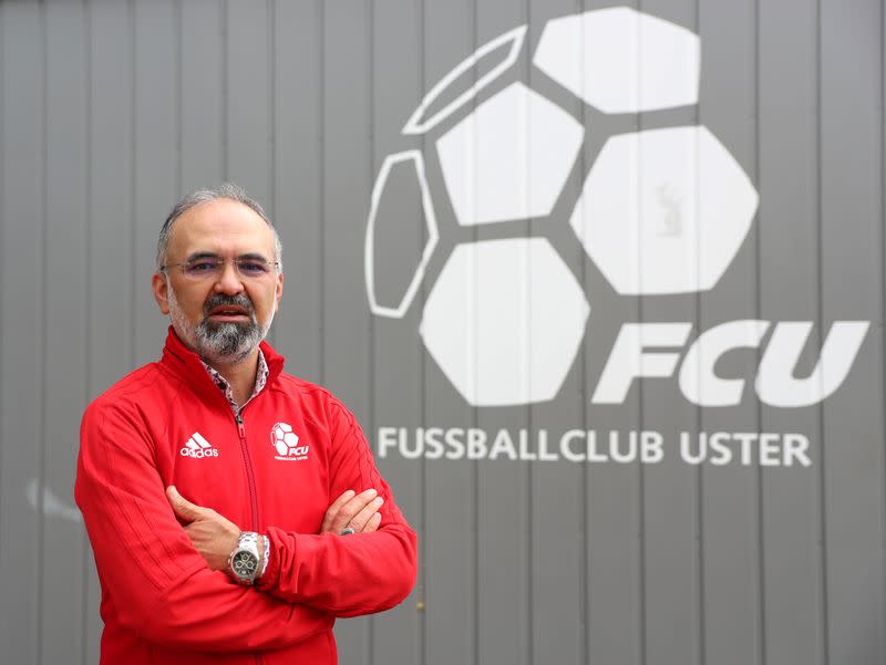 Ali Oezcan, vice-president of Swiss soccer club FC Uster poses in front of club logo in Uster