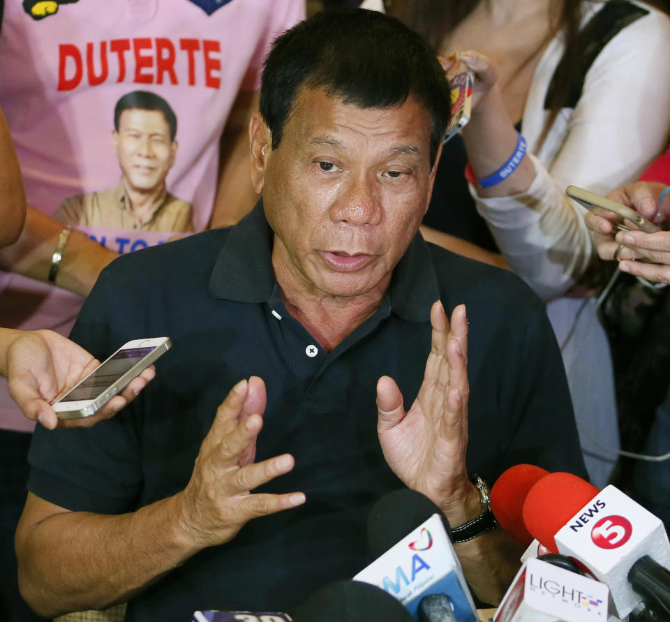 FILE - Presidential candidate Rodrigo Duterte answers questions from the media in Manila, Philippines, April 29, 2016. The Philippine government has asked the International Criminal Court to defer its crimes against humanity investigation linked to the country's "war on drugs," the court's chief prosecutor announced Tuesday, Nov. 23, 201. The request will delay the international probe into the deadly crackdown. (AP Photo/Bullit Marquez, File)