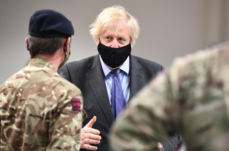 Britain's Prime Minister Boris Johnson meets troops as they set up a vaccination centre in the Castlemilk district in Glasgow, Scotland on January 28, 2021, during a COVID-19 related visit to the country. - Prime Minister Boris Johnson headed to Scotland on Thursday to praise the United Kingdom's collective response to coronavirus, in a bid to counter record support for independence. (Photo by Jeff J Mitchell / POOL / AFP) (Photo by JEFF J MITCHELL/POOL/AFP via Getty Images)