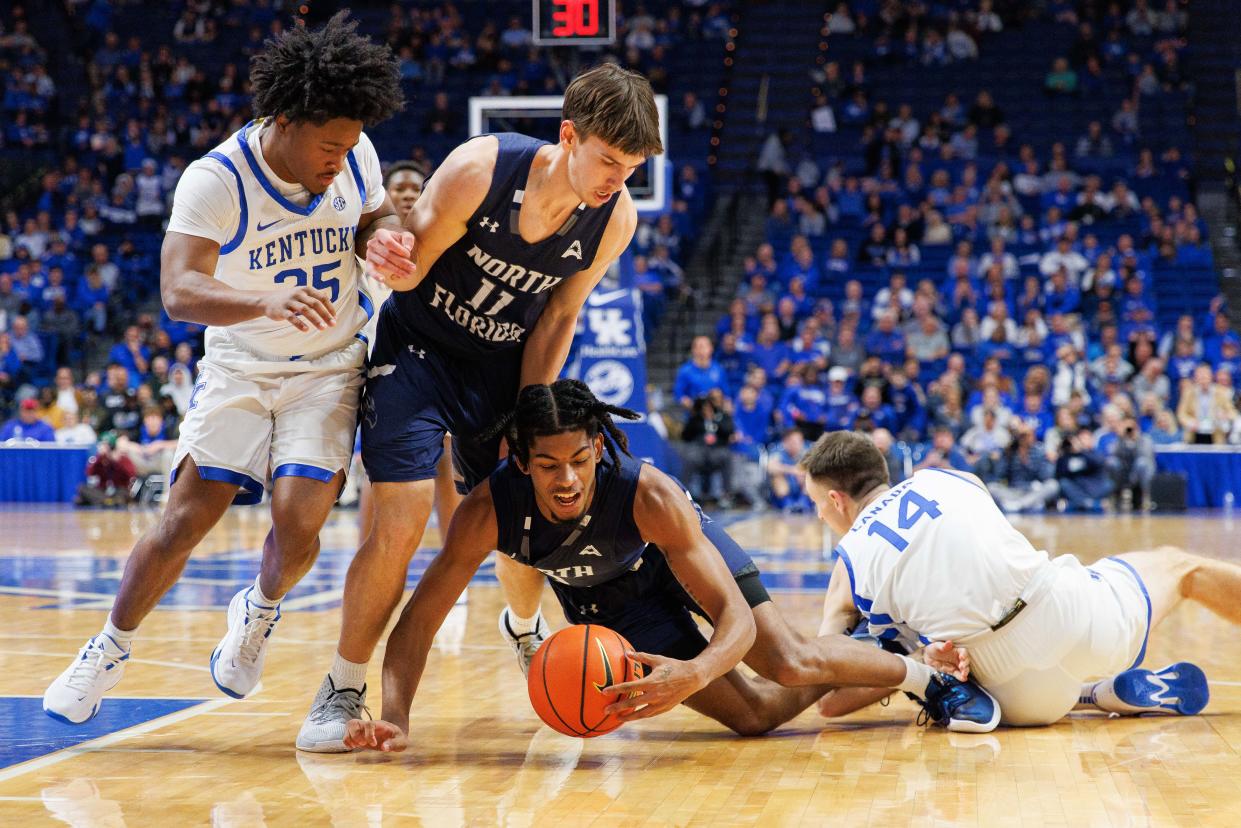 North Florida players Trent Coleman (on floor) and Brandon Rasmussen (11) go after a loose ball with Kentucky's Kareem Watkins (25) and Brennan Canada (14) during last week's game at Rupp Arena in Lexington, Ky.