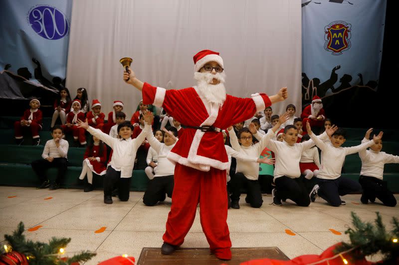 A Palestinian boy dressed as Santa Claus performs in a Christmas-themed show in College Des Freres school in Bethlehem in the Israeli-occupied West Bank
