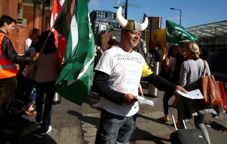 A striking Eurostar train manager and member of the RMT union, hands out leaflets on a picket line outside St. Pancras train station in London, Britain August 12, 2016. REUTERS/Peter Nicholls