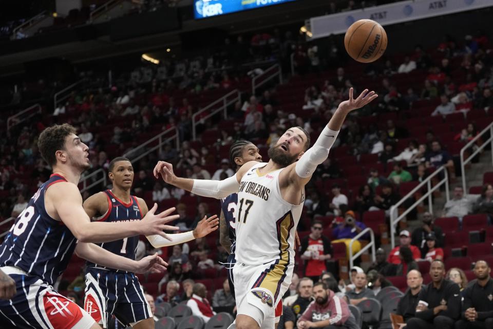 New Orleans Pelicans' Jonas Valanciunas (17) reaches for the ball as Houston Rockets' Alperen Sengun, left, defends during the second half of an NBA basketball game Friday, March 17, 2023, in Houston. The Rockets won 114-112. (AP Photo/David J. Phillip)