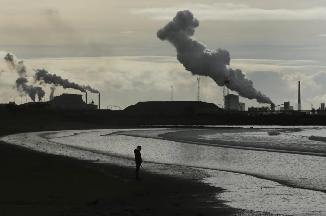 A man walks his dog on Aberavon beach near Port Talbot in Wales (Getty Images)