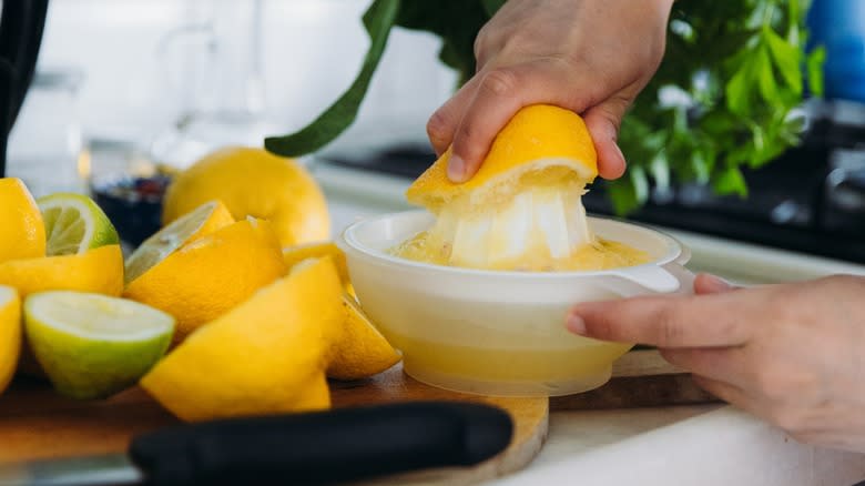 Hands juicing lemons with a traditional juicer