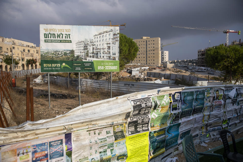 FILE - In this Nov. 10, 2020 file photo, a billboard advertises a new residential project at a construction site in the east Jerusalem Israeli settlement of Ramat Shlomo. Israel said Thursday, April 8, 2021, it will formally reject the International Criminal Court’s decision to launch a probe into potential war crimes against the Palestinians. The court is expected to look at possible war crimes committed by Israelis forces and Palestinian militants during and after the 2014 Gaza war, as well as Israel’s settlements in the West Bank and east Jerusalem. (AP Photo/Ariel Schalit, File)