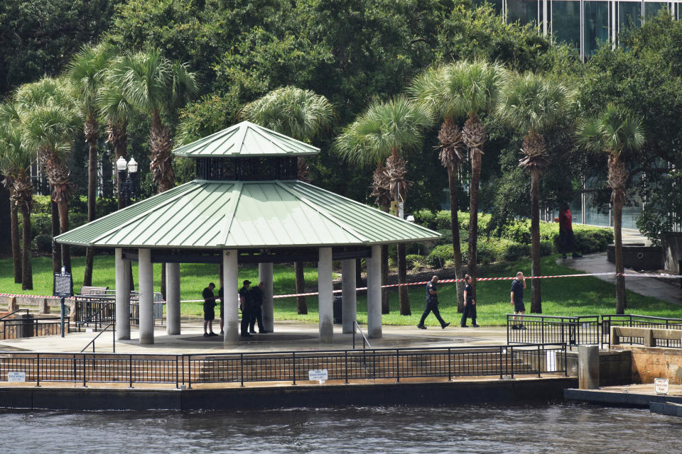 Police investigate the scene at the Jacksonville Landing Sunday, Aug. 26, 2018, after a mass shooting during a Madden Championship Series competition at the Good Luck Have Fun video game bar at The Jacksonville Landing in Jacksonville, Fla. A gunman opened fire Sunday during an online video game tournament that was being livestreamed from a Florida mall, killing multiple people and sending many others to hospitals, authorities said. (Will Dickey/The Florida Times-Union via AP)