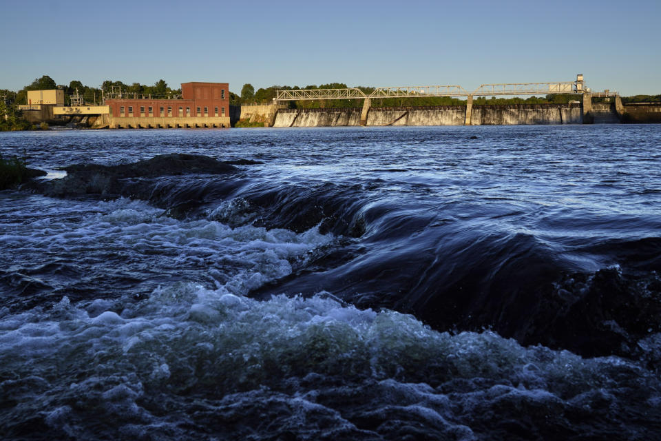 FILE - The Shawmut Dam spans the Kennebec River, Thursday, Sept. 15, 2021, between Fairfield and Benton, Maine. The last wild Atlantic salmon that return to U.S. rivers have had their most productive year in more than a decade. The salmon were once abundant in American rivers, but factors such as overfishing, loss of habitat and pollution reduced their populations to only a handful of rivers in Maine. The fish are protected by the Endangered Species Act, and sometimes only a few hundred of them return from the ocean to the rivers in a year. (AP Photo/Robert F. Bukaty)