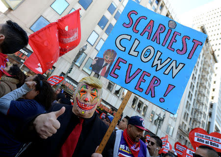 Protesters hold up signs during a march and rally against the United States President-elect Donald Trump in Los Angeles, California, U.S. December 18, 2016.REUTERS/Kevork Djansezian