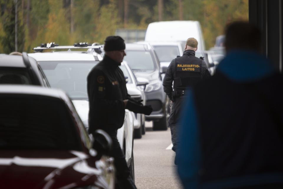 Finnish border guards check the cars at the Vaalimaa border check point between Finland and Russia in Virolahti, Eastern Finland Wednesday, Sept. 28, 2022. The mass exodus of men — alone or with their families or friends — began Sept. 21, shortly after Putin’s address to the nation, and continued all this week. Early on, they snapped up airline tickets, which spiked in price on the few airlines still flying out of Russia. But the rest had to gas up their cars and join the long lines snaking on roads toward the borders. (Sasu M'kinen/Lehtikuva via AP)