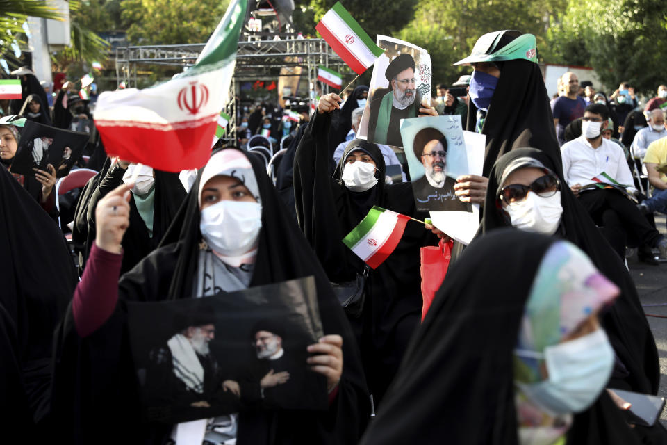 Supporters of presidential candidate Ebrahim Raisi hold signs during a rally in Tehran, Iran, Wednesday, June 16, 2021. Iran's clerical vetting committee has allowed just seven candidates for the Friday, June 18, ballot, nixing prominent reformists and key allies of President Hassan Rouhani. The presumed front-runner has become Ebrahim Raisi, the country's hard-line judiciary chief who is closely aligned with Supreme Leader Ayatollah Ali Khamenei. (AP Photo/Ebrahim Noroozi)