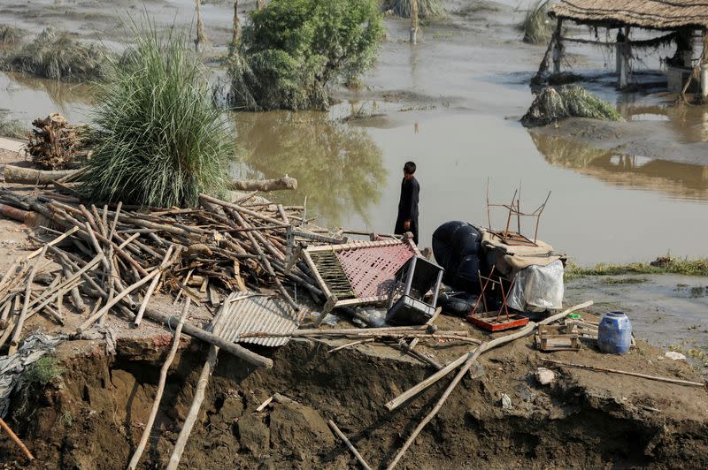 FILE PHOTO: A flood victim stands in his damaged house following rains and floods during the monsoon season, in Nowshera