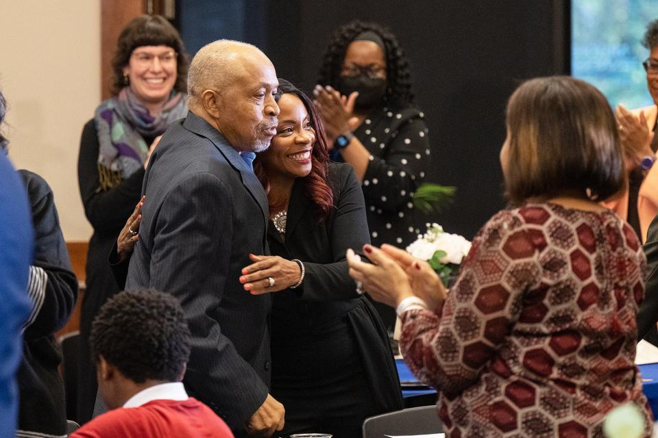 As family, friends and colleagues applaud, MTSU Health and Human Performance professor Chandra Russell Story, center, is hugged by her father, Eugene H. Russell III, after accepting the 2023 John Pleas Faculty Recognition Award during a special ceremony Tuesday, Feb. 21, at the Ingram Building’s MT Center.