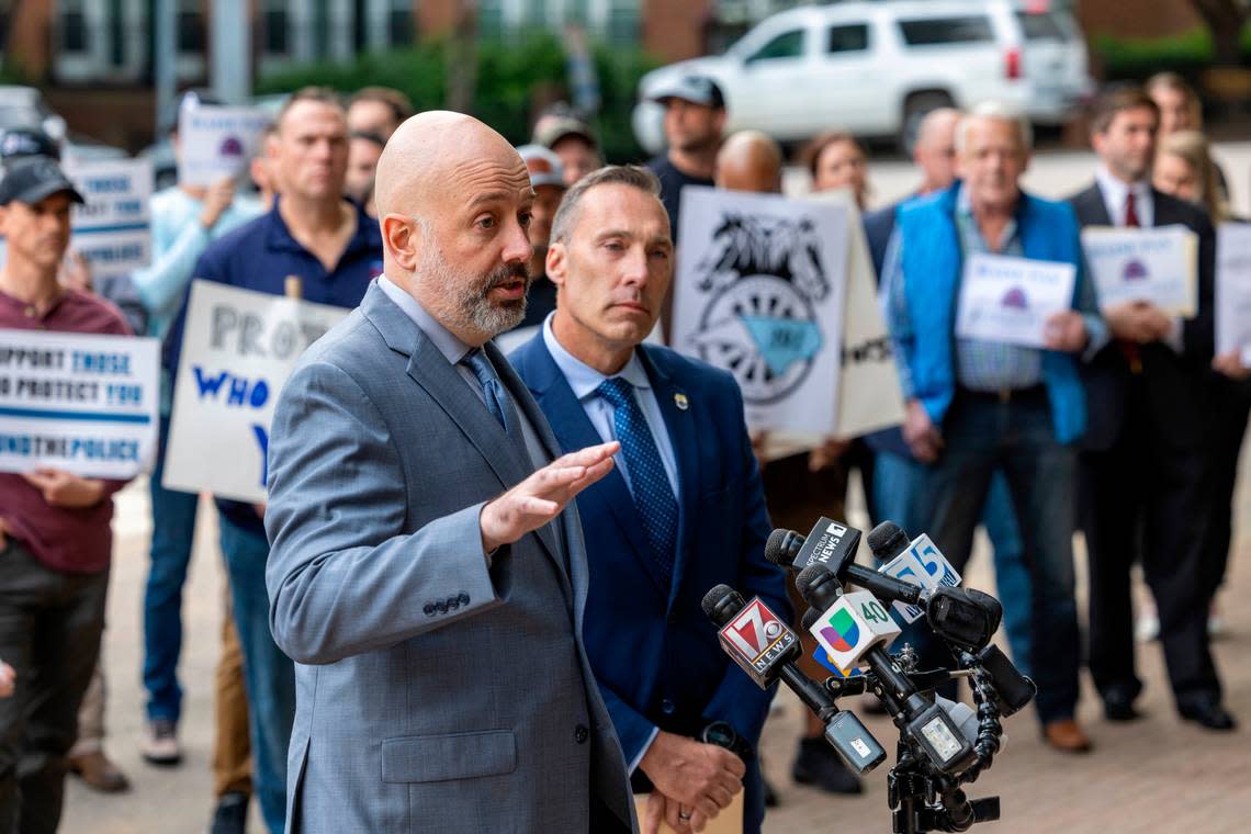 Matthew Cooper, president, left, and Rick Armstrong, spokesperson, for the Raleigh Police Protective Association along with dozens of police  officers, demand higher pay from the city of Raleigh during a rally outside city hall on Tuesday, April 9, 2024.
