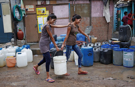 Girls carry a water container after filling it from a municipal tanker in New Delhi, India, June 26, 2018. REUTERS/Adnan Abidi