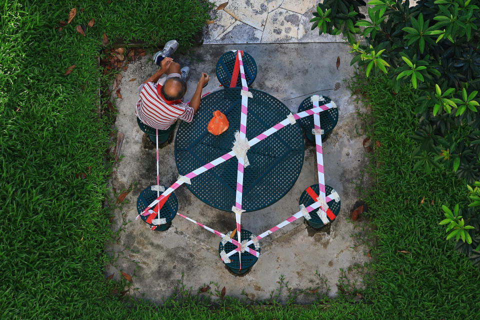 A man sits at a seating area taped off for safe distancing measure on 18 June, 2020 in Singapore. (PHOTO: Getty Images)