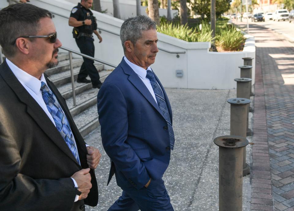 A federal agent (left) walks Carlos De Oliveira to the street as others exit the Alto Lee Adams Sr. U.S. Courthouse in Fort Pierce on Friday, April 12, 2024, following a hearing for De Oliveira and Waltine "Walt" Nauta, co-defendants with former President Trump in his classified documents case.